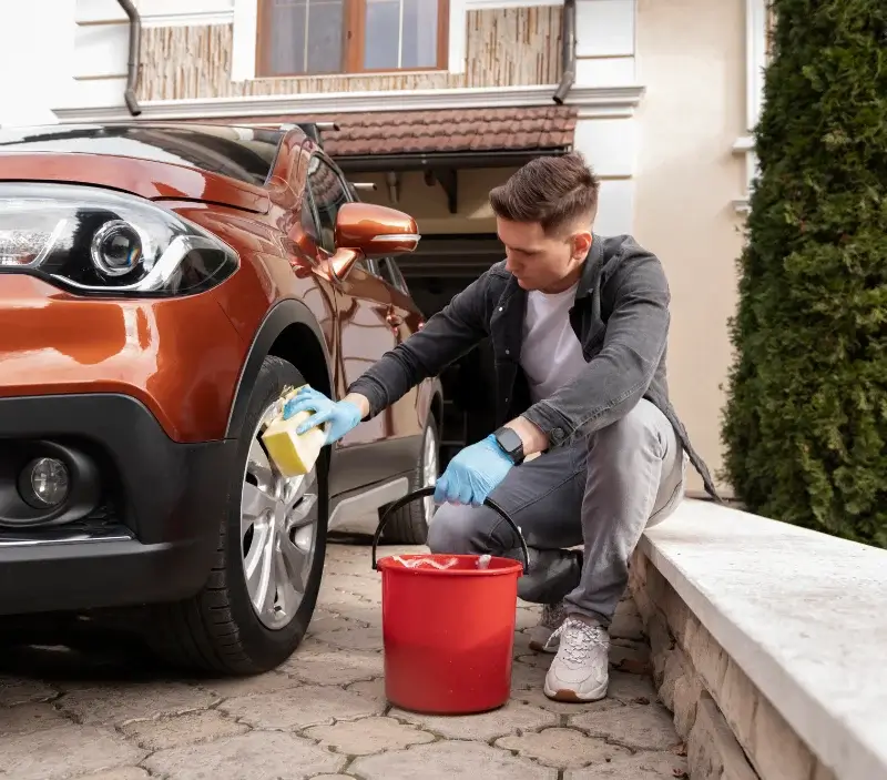 Lavage auto à domicile Le Mesnil-Rouxelin : professionnel intervenant sur un véhicule